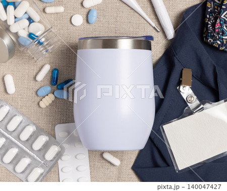 White 12 oz tumbler mockup with medical accessories and scrub uniform top view, blank template 140047427