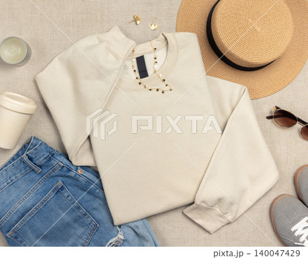 Blank beige unisex sweatshirt mockup, folded crewneck with copy space on front and sleeve Blank beige unisex sweatshirt mockup, folded crewneck with copy space on front and sleeve 140047429