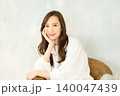 椅子に座って頬杖をつく 女性 140047439