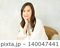 椅子に座って頬杖をつく 女性 140047441