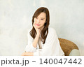 椅子に座って頬杖をつく 女性 140047442