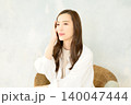 椅子に座って頬杖をつく 女性 140047444