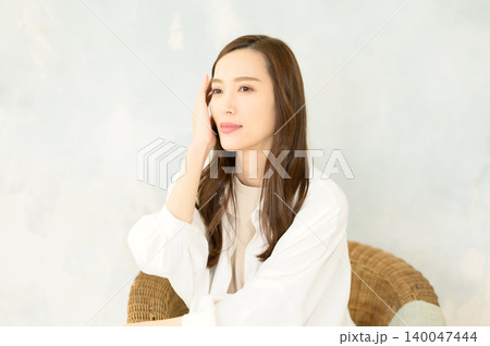 椅子に座って頬杖をつく 女性 椅子に座って頬杖をつく 女性 140047444