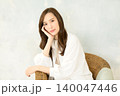 椅子に座って頬杖をつく 女性 140047446