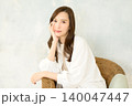 椅子に座って頬杖をつく 女性 140047447