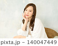 椅子に座って頬杖をつく 女性 140047449