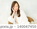 椅子に座って頬杖をつく 女性 140047450