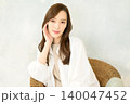 椅子に座って頬杖をつく 女性 140047452