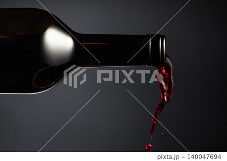 Red wine pours out of the bottle. Red wine pours out of the bottle. 140047694