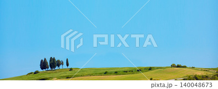 The picturesque landscape of Tuscany. Spring nature with blue sky and beautiful one cloud. Grassed rolling fields on hills 140048673