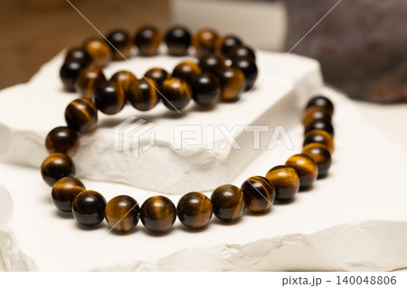 Tiger's eye stone jewelry displayed on a white surface Tiger's eye stone jewelry displayed on a white surface 140048806