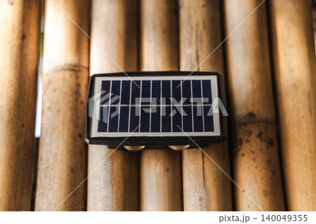 Solar powered wall light on bamboo background sustainable outdoor energy solution Solar powered wall light on bamboo background sustainable outdoor energy solution 140049355