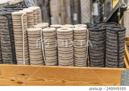 Rolled carpet runners and striped floor mats in home improvement store display 140049389
