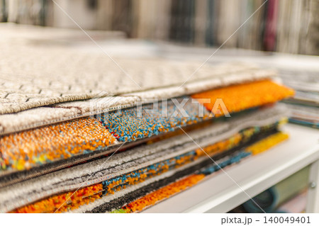 Stack of colorful carpet samples and decorative rugs in home improvement store Stack of colorful carpet samples and decorative rugs in home improvement store 140049401