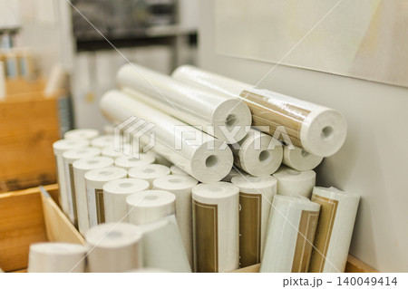 Stacked white wallpaper rolls and renovation materials displayed in hardware store interior 140049414