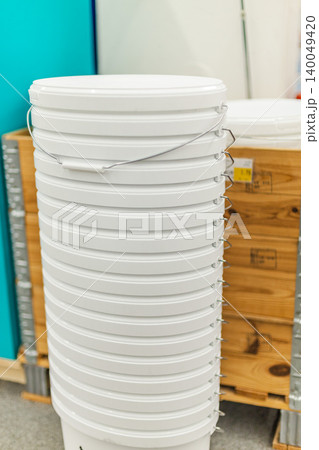 Stack of white plastic paint buckets in hardware store renovation supplies section Stack of white plastic paint buckets in hardware store renovation supplies section 140049420