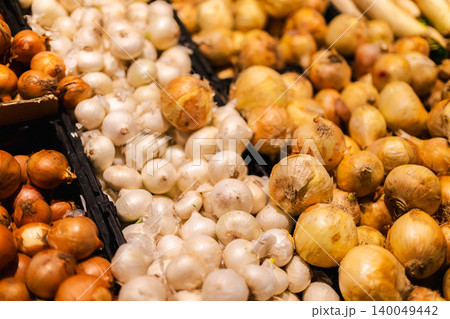 Fresh white and brown onions displayed in supermarket produce section with organic vegetables and healthy grocery shopping concept Fresh white and brown onions displayed in supermarket produce section with organic vegetables and healthy grocery shopping concept 140049442