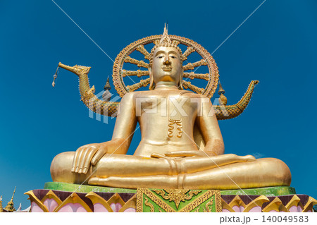 Golden Big Buddha statue at Wat Phra Yai temple on Koh Samui island in Thailand against blue sky Golden Big Buddha statue at Wat Phra Yai temple on Koh Samui island in Thailand against blue sky 140049583