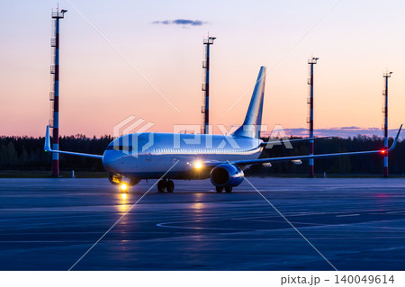 Modern passenger plane taxiing at the airport against the backdrop of a scenic sunset Modern passenger plane taxiing at the airport against the backdrop of a scenic sunset 140049614