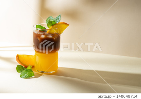 Cold bumble coffee with orange juice and ice on yellow background 140049714