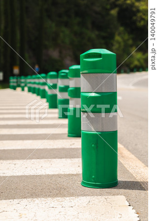 Green reflective traffic bollards marking pedestrian crossing on mountain road in Montserrat Spain Green reflective traffic bollards marking pedestrian crossing on mountain road in Montserrat Spain 140049791