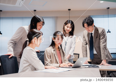 オフィスのチームで笑顔でパソコン画面を見る社員 オフィスのチームで笑顔でパソコン画面を見る社員 140049850