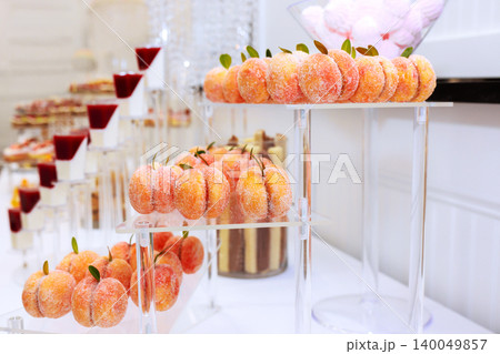 Dessert table features fruit shaped treats organized carefully for guests various sweets at event. Dessert table features fruit shaped treats organized carefully for guests various sweets at event. 140049857