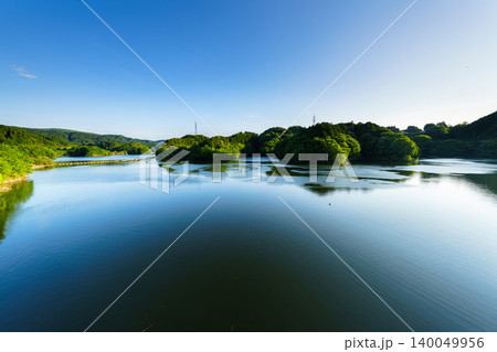 初夏の布目ダム なみなみと水を湛え湖面に映る青空と夕日に照らされる湖岸① 初夏の布目ダム なみなみと水を湛え湖面に映る青空と夕日に照らされる湖岸① 140049956