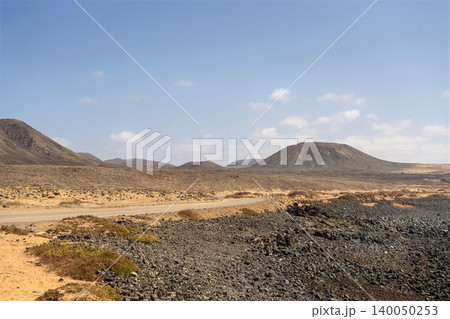 Wide view of Lanzarote desert landscape with volcanic hills and stark island beauty Wide view of Lanzarote desert landscape with volcanic hills and stark island beauty 140050253