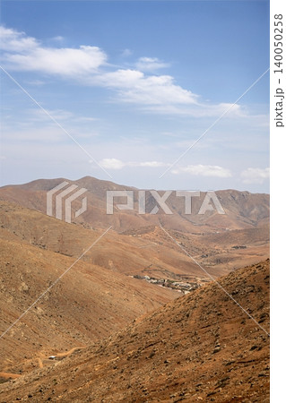 Wide view of Lanzarotes desert landscape with volcanic hills and stark island beauty 140050258