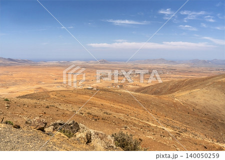 Wide view of Lanzarotes desert landscape with volcanic hills and stark island beauty Wide view of Lanzarotes desert landscape with volcanic hills and stark island beauty 140050259