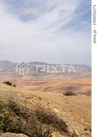 Wide view of Lanzarote desert landscape with volcanic hills and stark island beauty Wide view of Lanzarote desert landscape with volcanic hills and stark island beauty 140050271