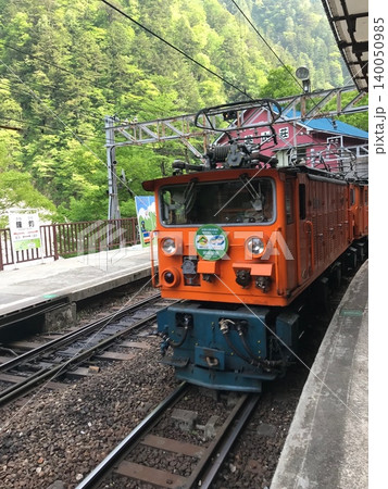 黒部峡谷鉄道の鐘釣駅に停車するオレンジ色の電気機関車とトロッコ列車 黒部峡谷鉄道の鐘釣駅に停車するオレンジ色の電気機関車とトロッコ列車 140050985