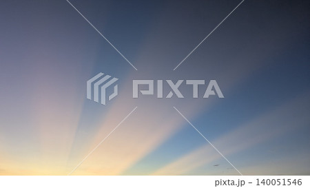 Vast dawn sky features a gorgeous natural gradient color palette shifting smoothly from deep twilight blue down to a warm orange glow along the lower horizon line. Thin wispy cloud layers catch the 140051546