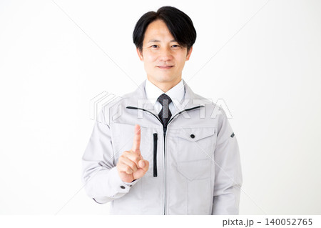 人差し指を立てるグレーの作業着姿のミドル男性ビジネスマン白バック 140052765