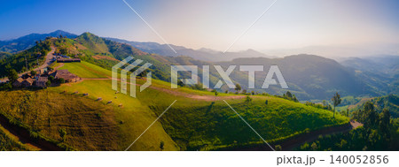 Panorama landscape of Beautiful sunrise mountain view with morning mist there is a sheep-lined street and cafes for relaxation and sightseeing at Doi Chang, Chiang Rai, Thailand Panorama landscape of Beautiful sunrise mountain view with morning mist there is a sheep-lined street and cafes for relaxation and sightseeing at Doi Chang, Chiang Rai, Thailand 140052856