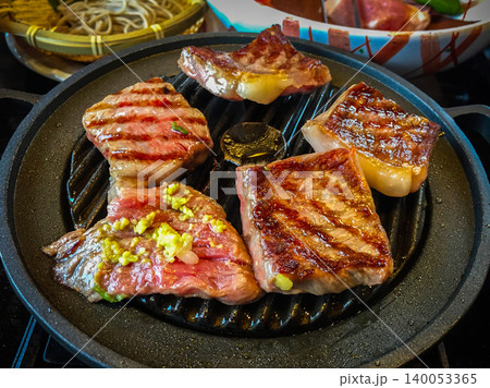 Large pieces of marbled wagyu beef grilled on a pan are a high quality and famous premium beef from Hida, Japan. 140053365