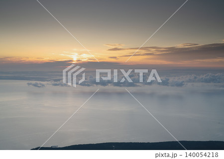 北海道の山頂から望むご来光と雲海、太陽の光芒と雲のレイヤー、9月の初秋の高山絶景 北海道の山頂から望むご来光と雲海、太陽の光芒と雲のレイヤー、9月の初秋の高山絶景 140054218