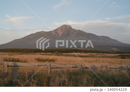 北海道の利尻富士と夕陽に染まる山肌、草原と木の柵、9月の初秋の利尻島ドラマチック絶景 北海道の利尻富士と夕陽に染まる山肌、草原と木の柵、9月の初秋の利尻島ドラマチック絶景 140054229