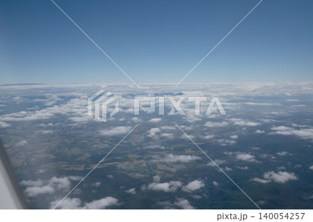 北海道上空から望む雲海と田園パノラマ、青空と遠景の山並み、8月の真夏の空撮絶景 北海道上空から望む雲海と田園パノラマ、青空と遠景の山並み、8月の真夏の空撮絶景 140054257