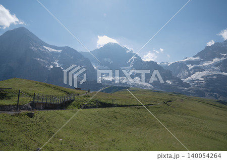 スイスアルプスの雪山と緑の草原、夏の高山牧草地、8月の真夏のスイス絶景パノラマ スイスアルプスの雪山と緑の草原、夏の高山牧草地、8月の真夏のスイス絶景パノラマ 140054264