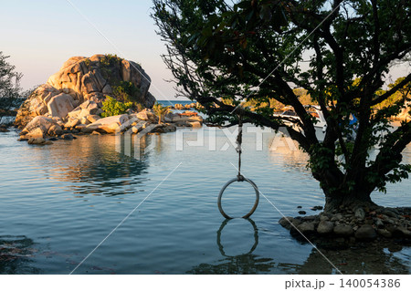 Tree with swing by small island at sunrise, Ko Man Klang, Rayong 140054386