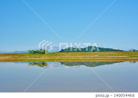 田植え前の田園のハサ木・水田に映る残雪の越後三山 田植え前の田園のハサ木・水田に映る残雪の越後三山 140054468