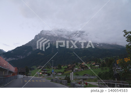 スイスのグリンデルワルト村と雲かかるアイガー北壁、薄暮の街並み、8月の真夏のスイス夕景 スイスのグリンデルワルト村と雲かかるアイガー北壁、薄暮の街並み、8月の真夏のスイス夕景 140054583