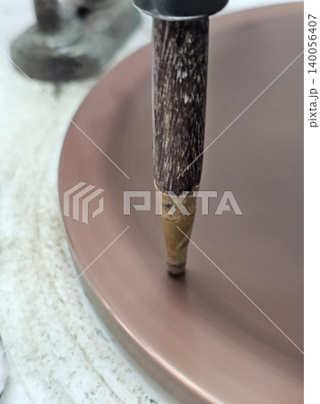 Close-up of Artisanal Metal Spinning Process with Rotating Copper Plate and Tool Close-up of Artisanal Metal Spinning Process with Rotating Copper Plate and Tool 140056407