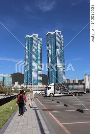 青空の下にそびえ立つ高層マンションと歩く観光客 140056585