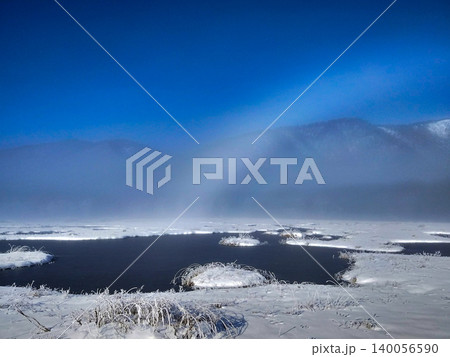 初冬の尾瀬ヶ原に架かる白虹と凍てつく池塘 コピースペースのある雪景色の自然風景 初冬の尾瀬ヶ原に架かる白虹と凍てつく池塘 コピースペースのある雪景色の自然風景 140056590