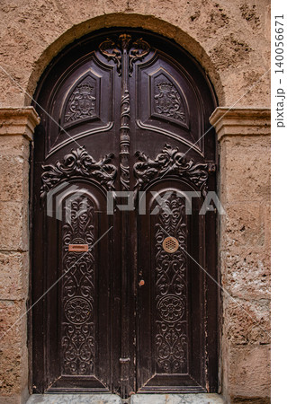 Intricate wooden door with ornate carvings in a historic building 140056671