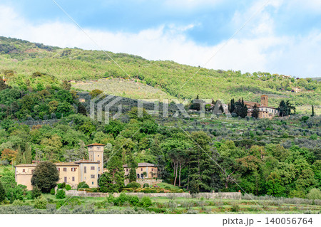 Stunning view of rolling hills with olive groves and historic buildings in Tuscany, Italy 140056764