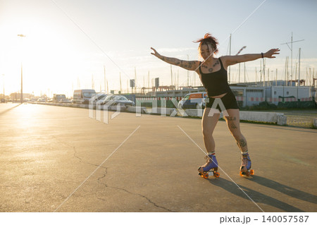 Woman roller skating at sunset feeling freedom Woman roller skating at sunset feeling freedom 140057587